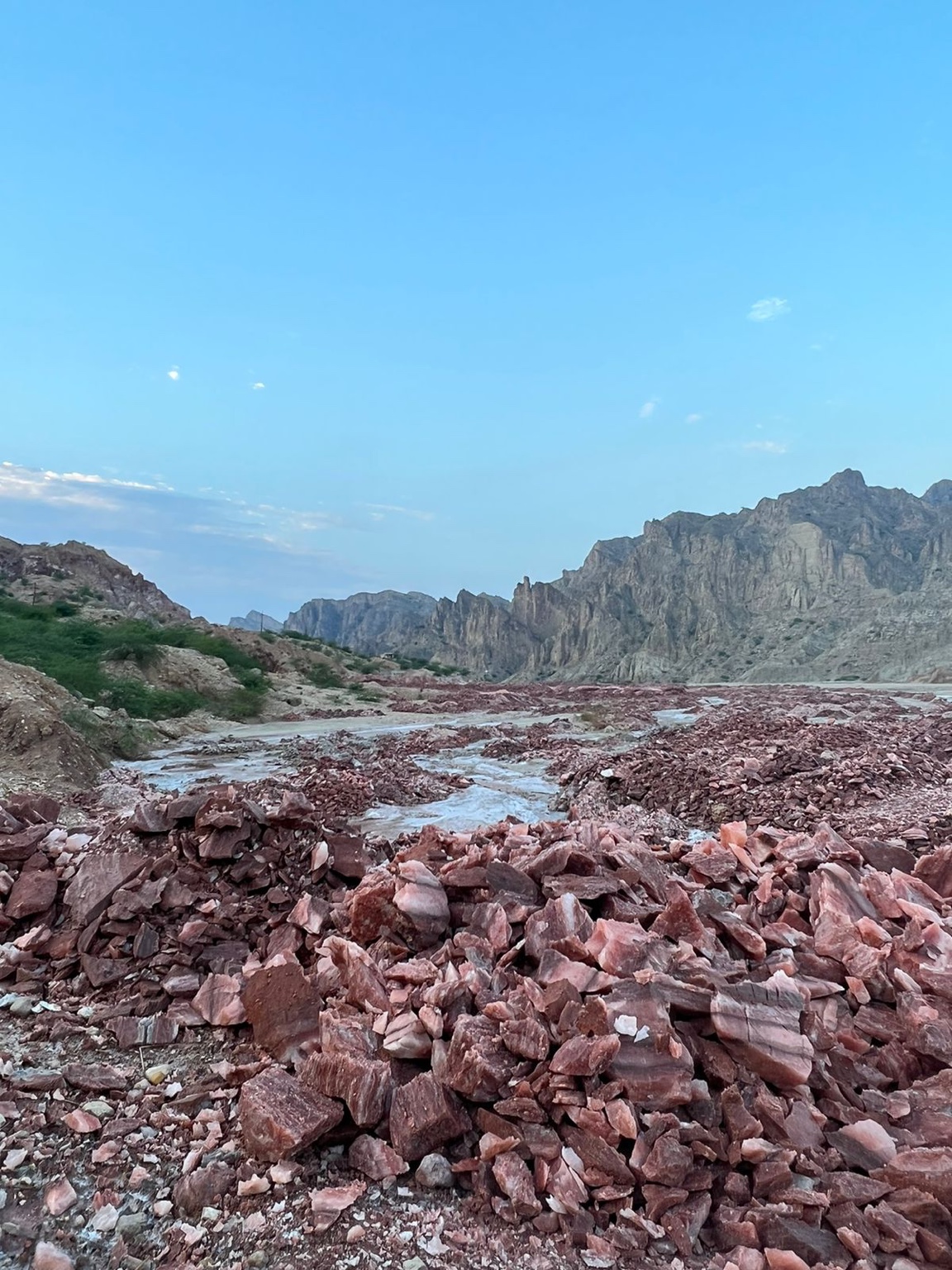 Natural pink and reddish Himalayan rock salt piled across the rocky Salt Range landscape in Pakistan